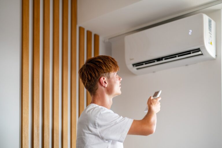 Kontakt 1 Mężczyzna ustawiający klimatyzację ścienną pilotem